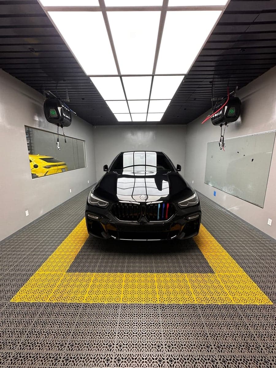 Black BMW X6 in detailing booth under studio lights