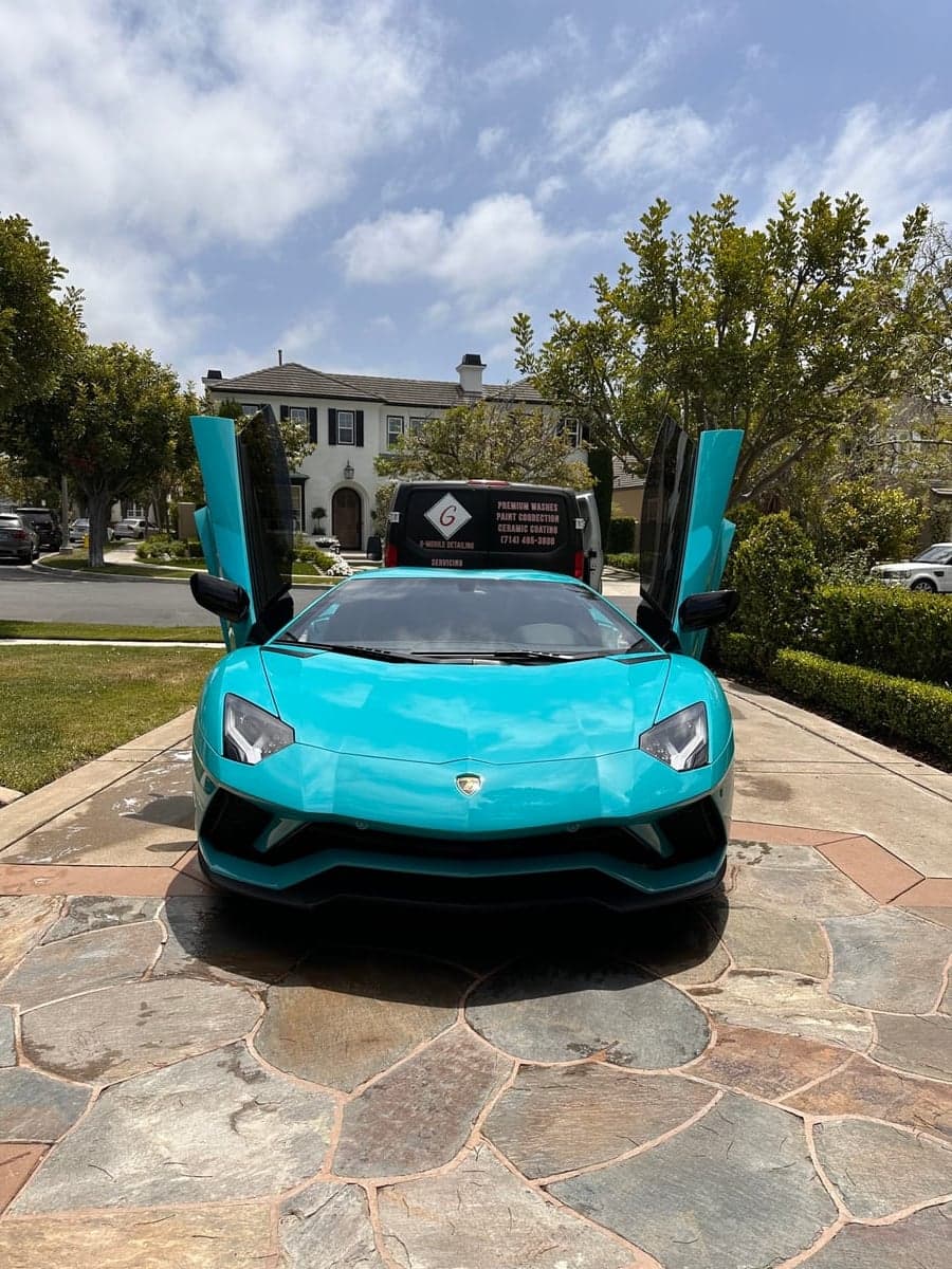 Baby blue Lamborghini Aventador front view with G Mobile van